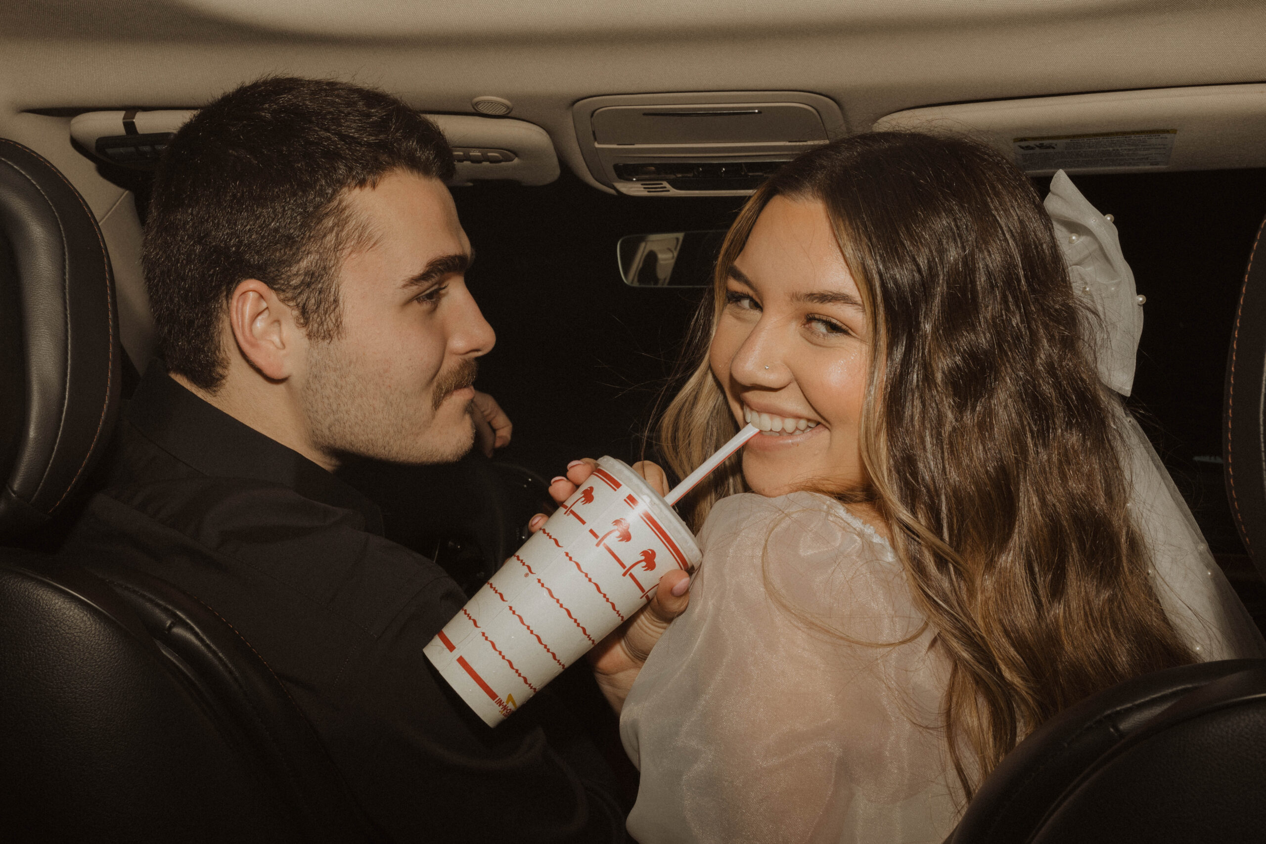 Bride and groom eating in-n-out after their wedding reception