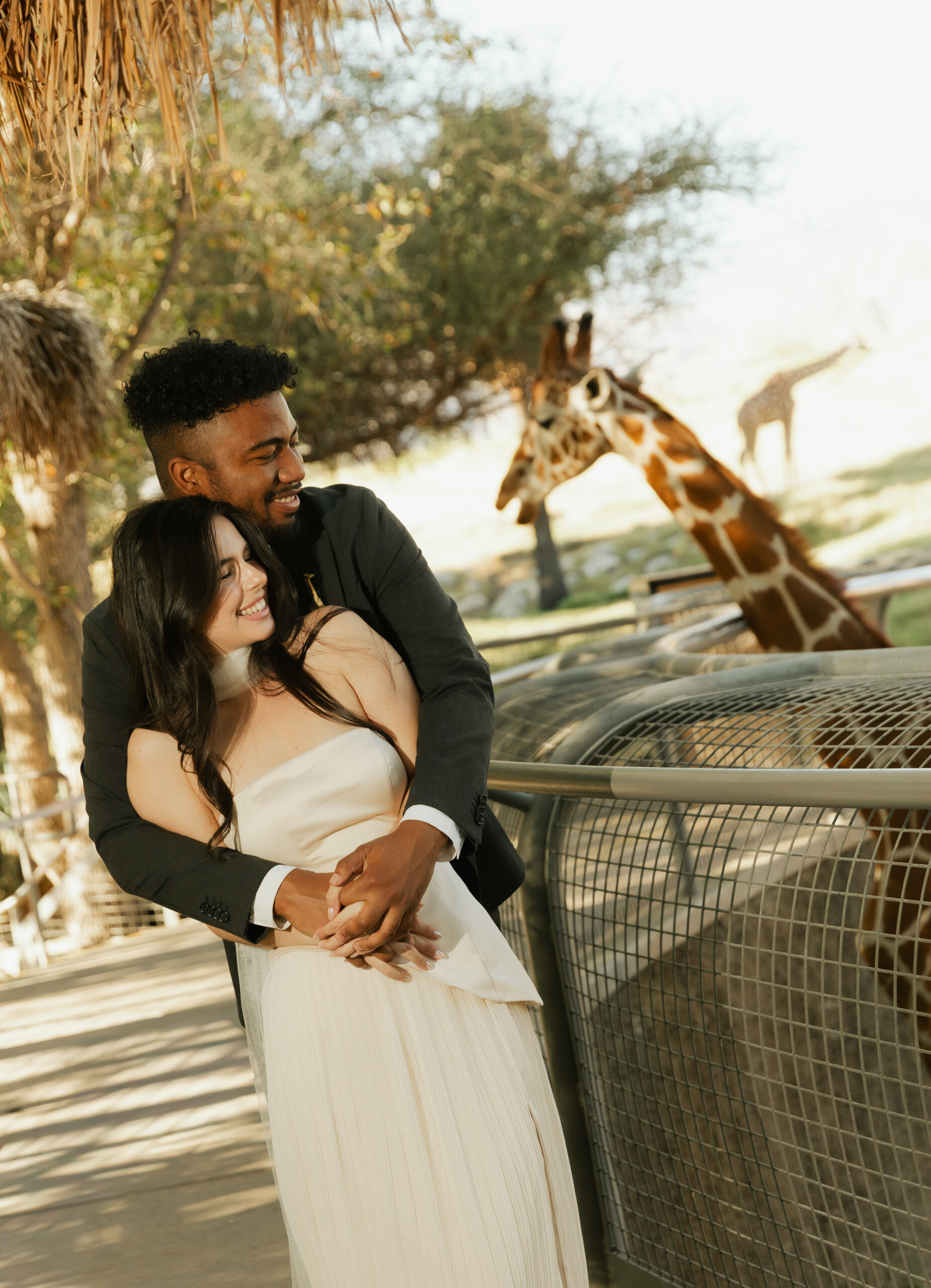 Bride and groom feeding a giraffe at The Living Desert Zoo & Gardens wedding venue in Palm Desert, California