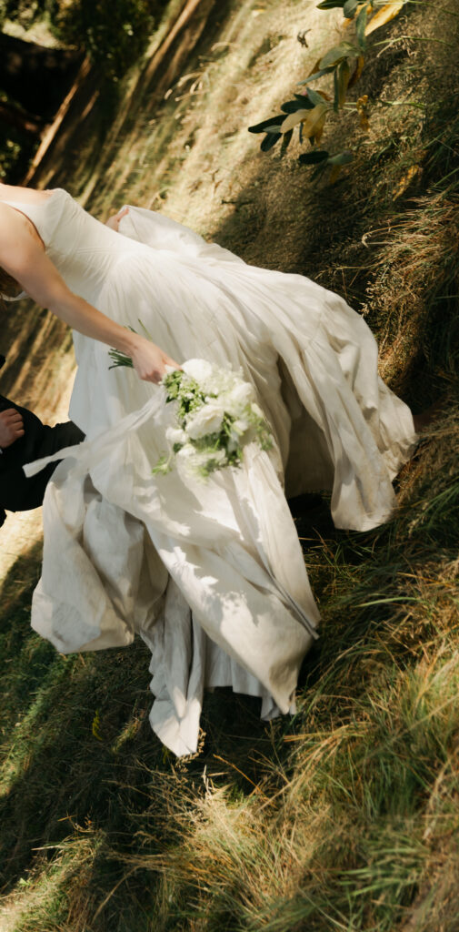 Bride walking through the grass in her wedding dress during afternoon portraits in Yosemite Valley