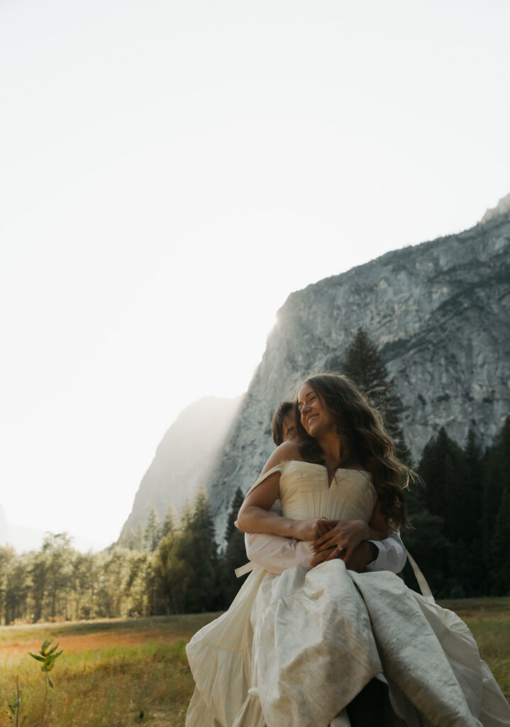 Newlyweds cuddling in Yosemite Valley during their golden hour wedding portraits