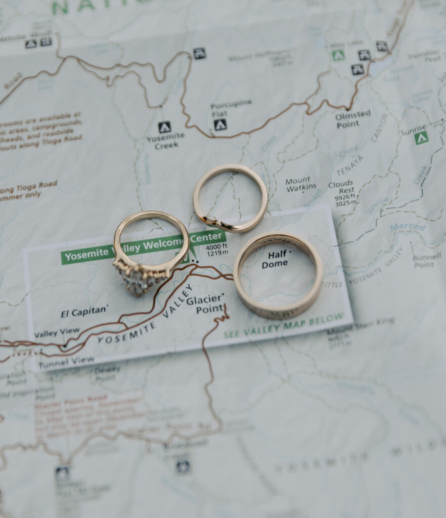 Wedding rings placed on a Yosemite National Park map featuring Yosemite Valley, Glacier Point and Half Dome