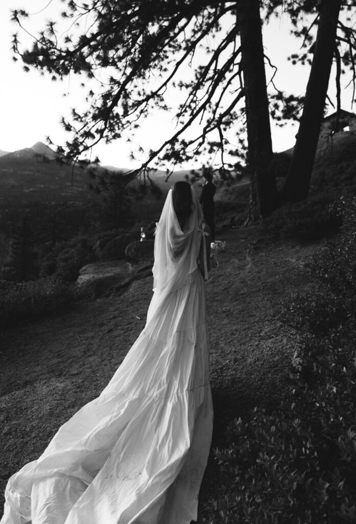Bride walking through the trees before sunrise for her Glacier Point elopement in Yosemite