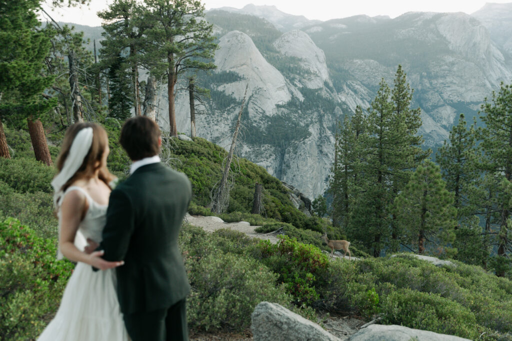 Newlyweds exploring a quiet overlook at Glacier Point during their Yosemite wedding
