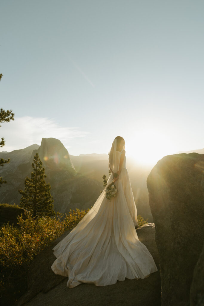 Bride standing in golden morning light with Half Dome behind her during her Yosemite micro wedding